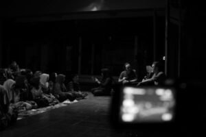 A man is interviewed on stage while audience watches.